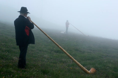  Alphorn blowers in fog before performing an ensemble piece on the last day of the international alphorn festival on the alp of Tracouet in Nendaz, in southern Switzerland, July 27, 2014. About 150 alphorn blowers took part in the contest this year.   REUTERS/Pierre Albouy (SWITZERLAND)