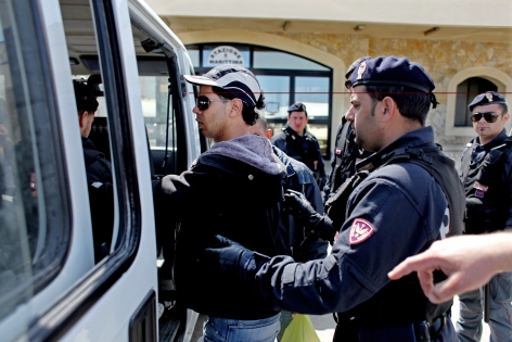  Lampedusa, Italie, le 13 avril 2011.
Des migrants d'origines tunisiennes arrivés illégalement la veille par bateau sont fransférés vers le centre de transit par la police. 
©Pierre Albouy